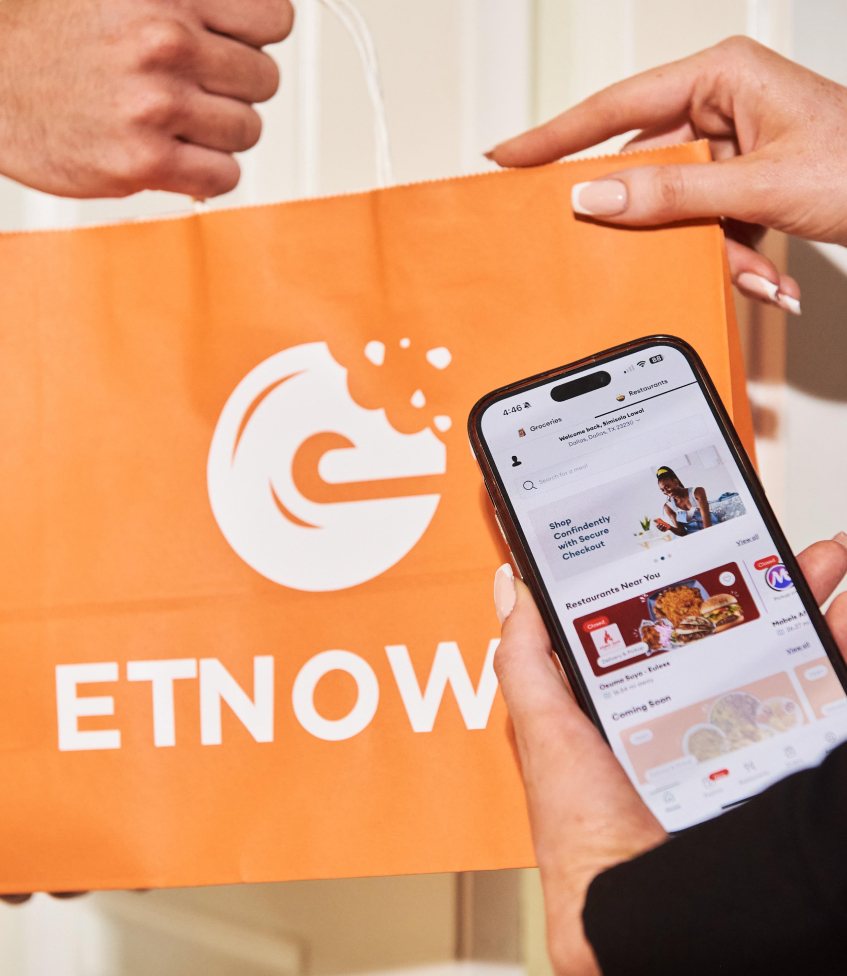 A customer receiving an ETNOWE delivery while using the app