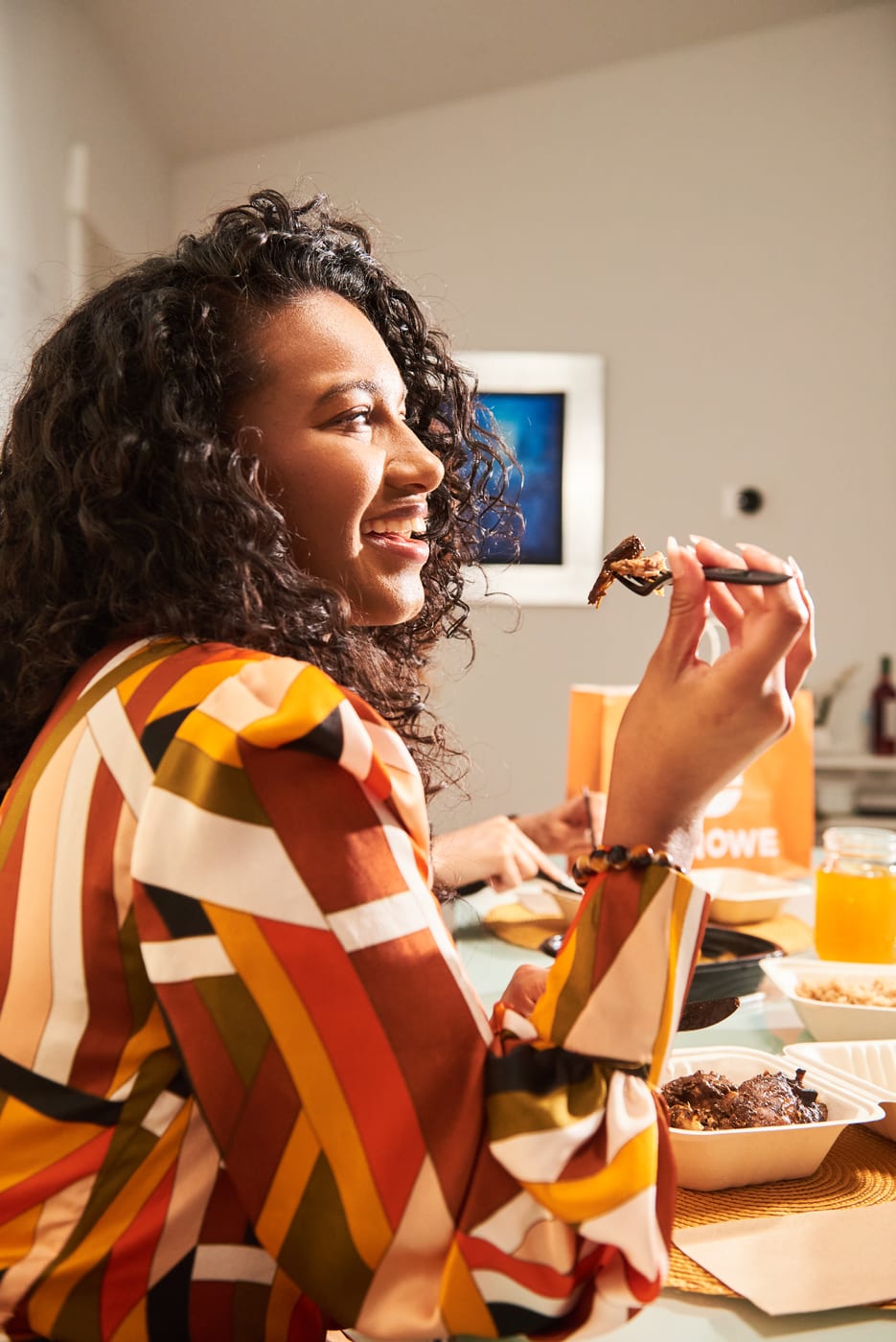 An ETNOWE customer enjoying a delivered meal at home